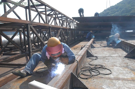 昨日下午3时,乌龙江铁路大桥建设工地,电焊工人正在表面高达60多摄氏