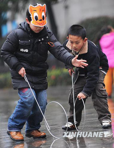 2月5日,两位小朋友在滚铁环.