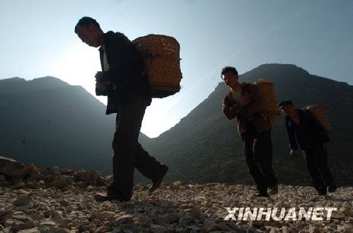 2月22日，在广西隆林县徳峨乡常么村，村民从山洞里取地下水后背水回家。新华社记者 黄孝邦 摄