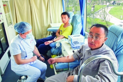 郭明义(右一)在献血车上。