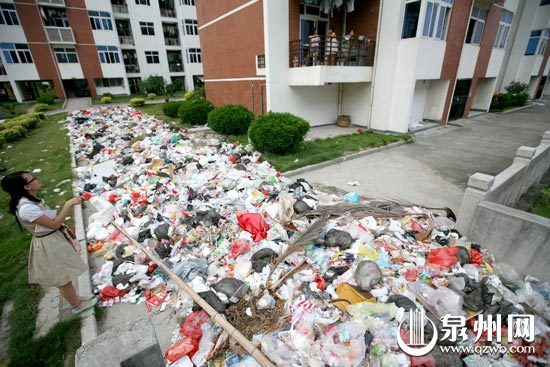 相关报道>>> 垃圾绵延几十米 学生宿舍开门臭关门热 垃圾满地,部分学生在宿舍都不敢开窗。 早报讯(记者颜雅婷 石勇 文/图)昨日下午,网友0595泉州三巷官方微博在个人微博上发了一张遍地是垃圾的图片,称泉州学院学生公寓C区垃圾成山,已持续半个月之久,记者随即驱车前往现场看个究竟。 下午近5时,学生或军训、或上课未回宿舍,C区公寓显得有些安静。记者进C区大门后往右走,在9号楼后的绿地上见到了照片中那片绵延的垃圾堆,满地的垃圾堆约有四五十米长,覆盖原本绿色的草坪和通道,各种塑料