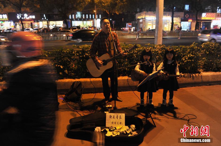 父亲带6岁双胞胎萝莉卖唱 成冬日福州街头风景线