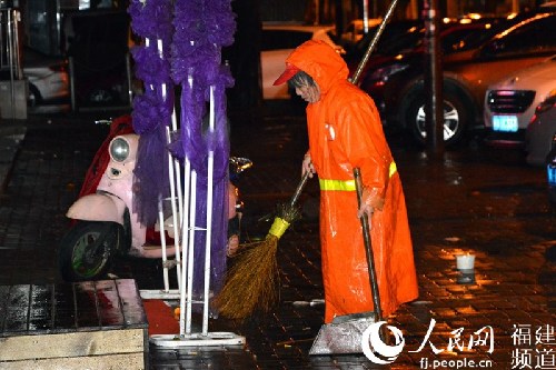 23日凌晨五点半，在福州市交通路人行道上清扫路面的环卫工。李挺摄