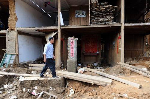 福建省建阳市将口镇芹口村,一位村民从受损严重的房屋前走过(6月28日